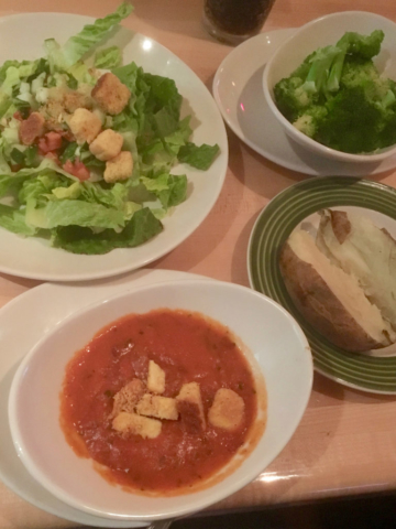 Vegan eating out at a restaurant, getting lots of sides: salad, steamed veg, baked potato and tomato soup
