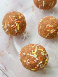 a plate of vegan date dough balls with natural sprinkles