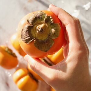 Holding a fuyu persimmon