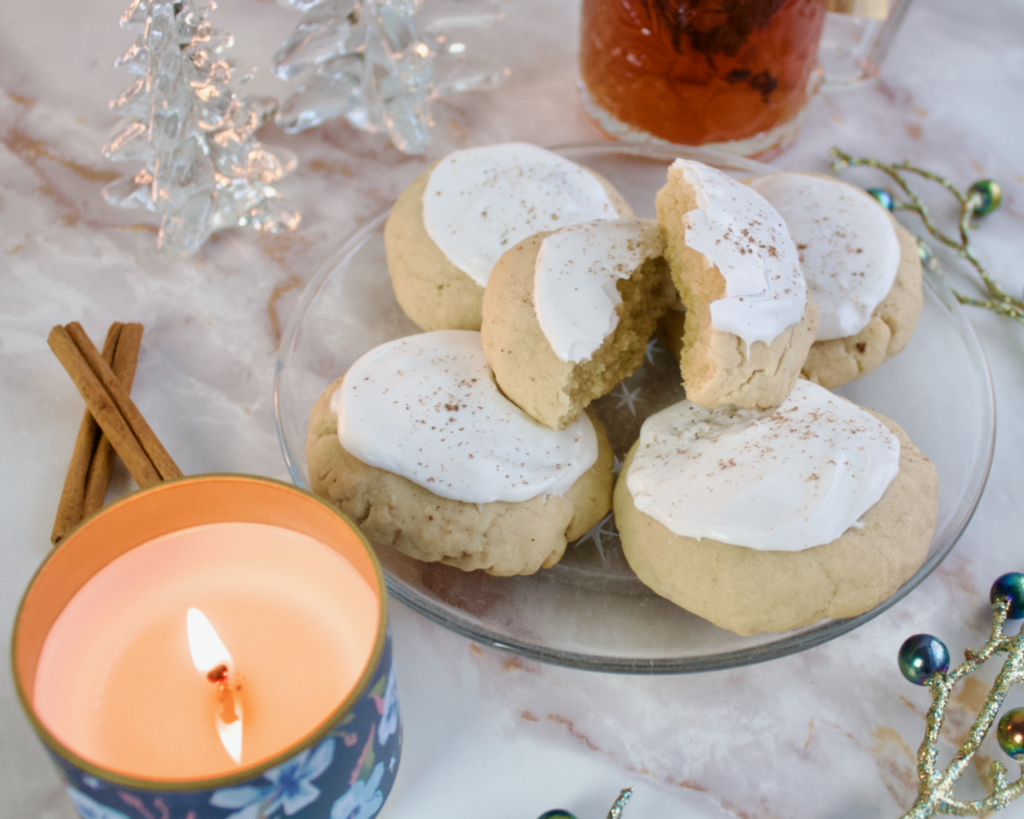 Taylor's chai sugar cookies staged with a candle, cinnamon sticks, tea and glass Christmas trees